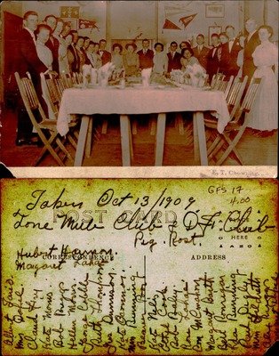 Group gathered around banquet table in hall with pennants